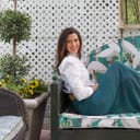Image of a woman sitting on a couch outdoors in a garden