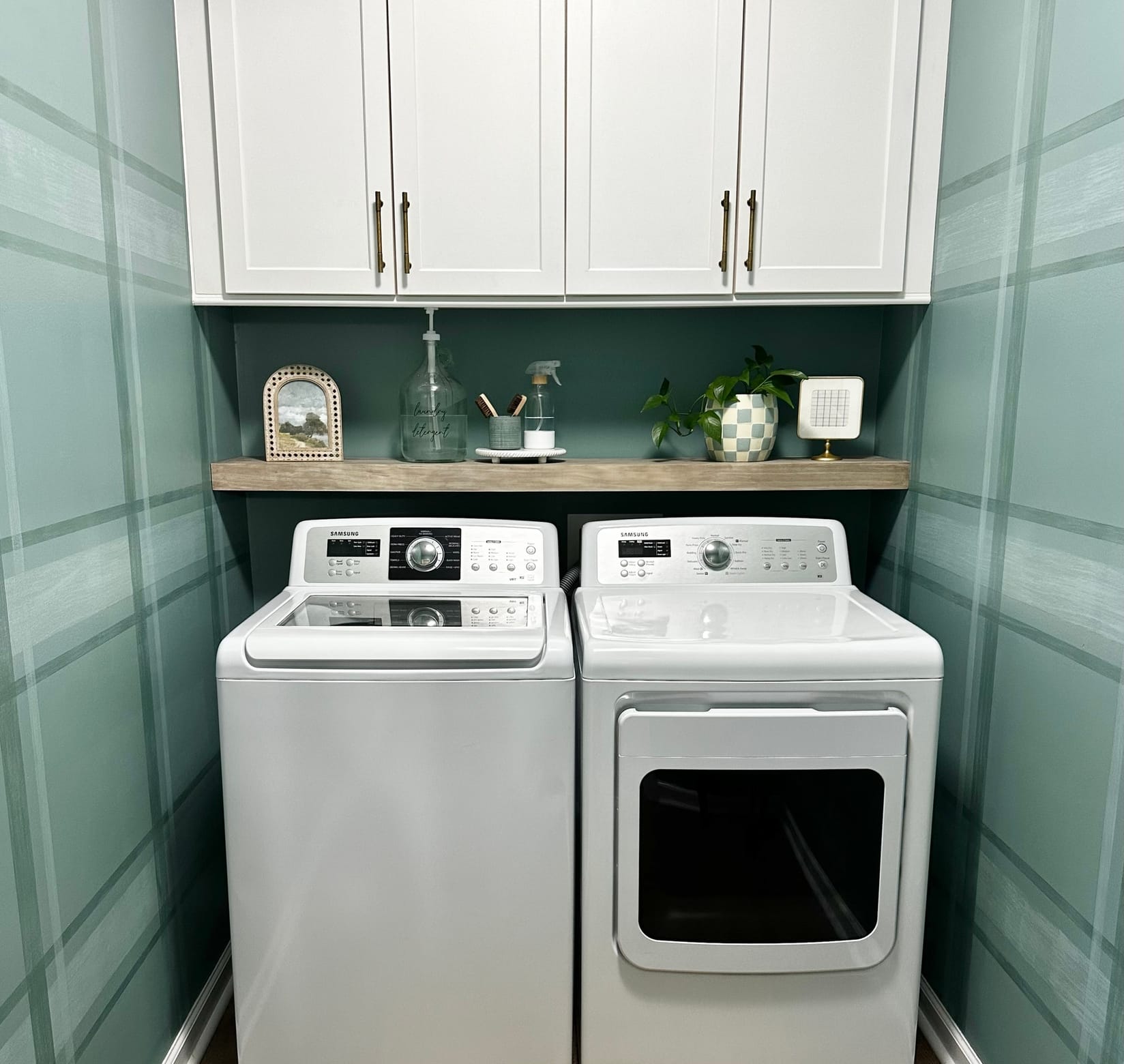 Modern Laundry Room with Washer, Dryer, shelf above, and upper cabinets. The walls are blue/green with a plaid pattern