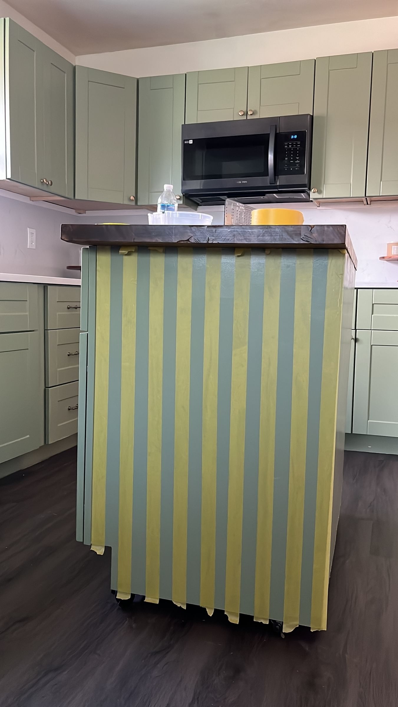 Green kitchen island with vertical stripes of yellow FrogTape Delicate Surface Painter's Tape