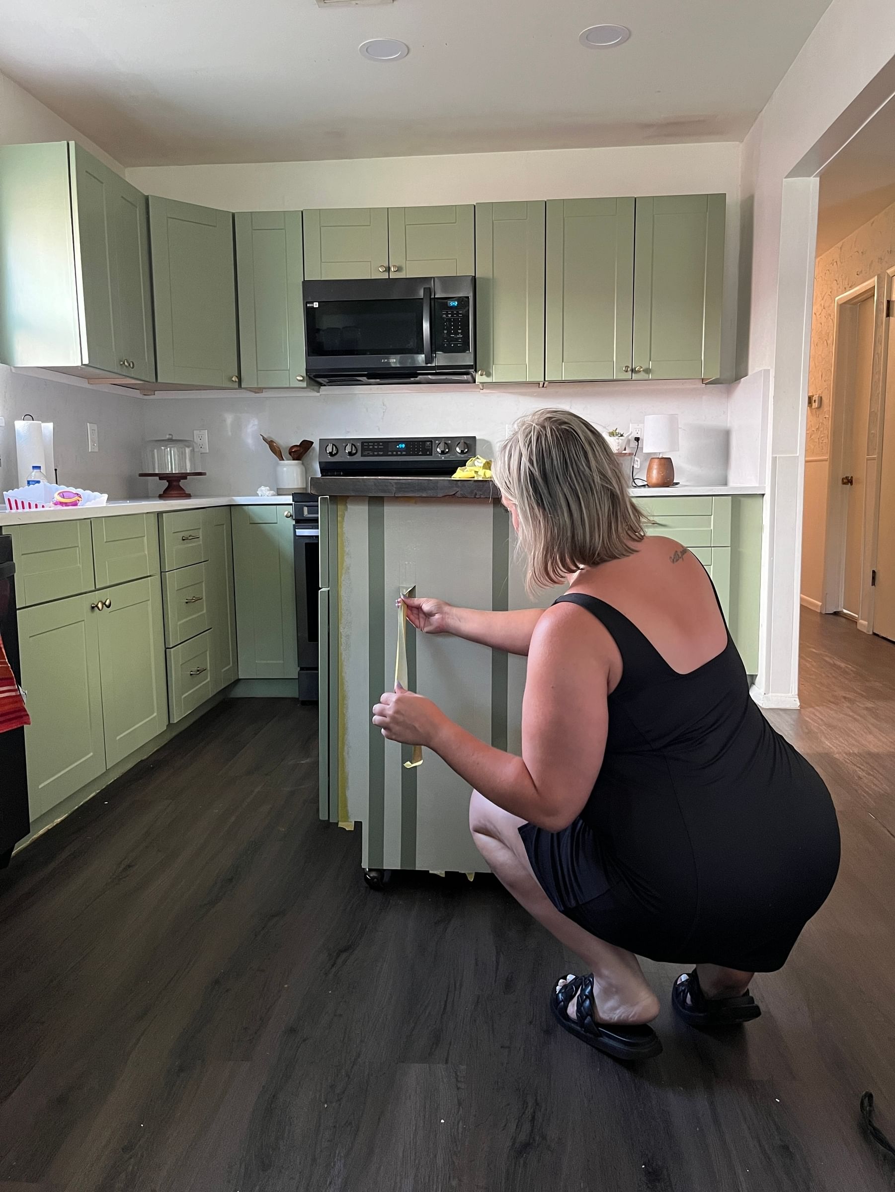 Jess Smith removing the Yellow FrogTape Delicate Surface Painter's Tape off of a Kitchen Island to reveal crisp paint lines