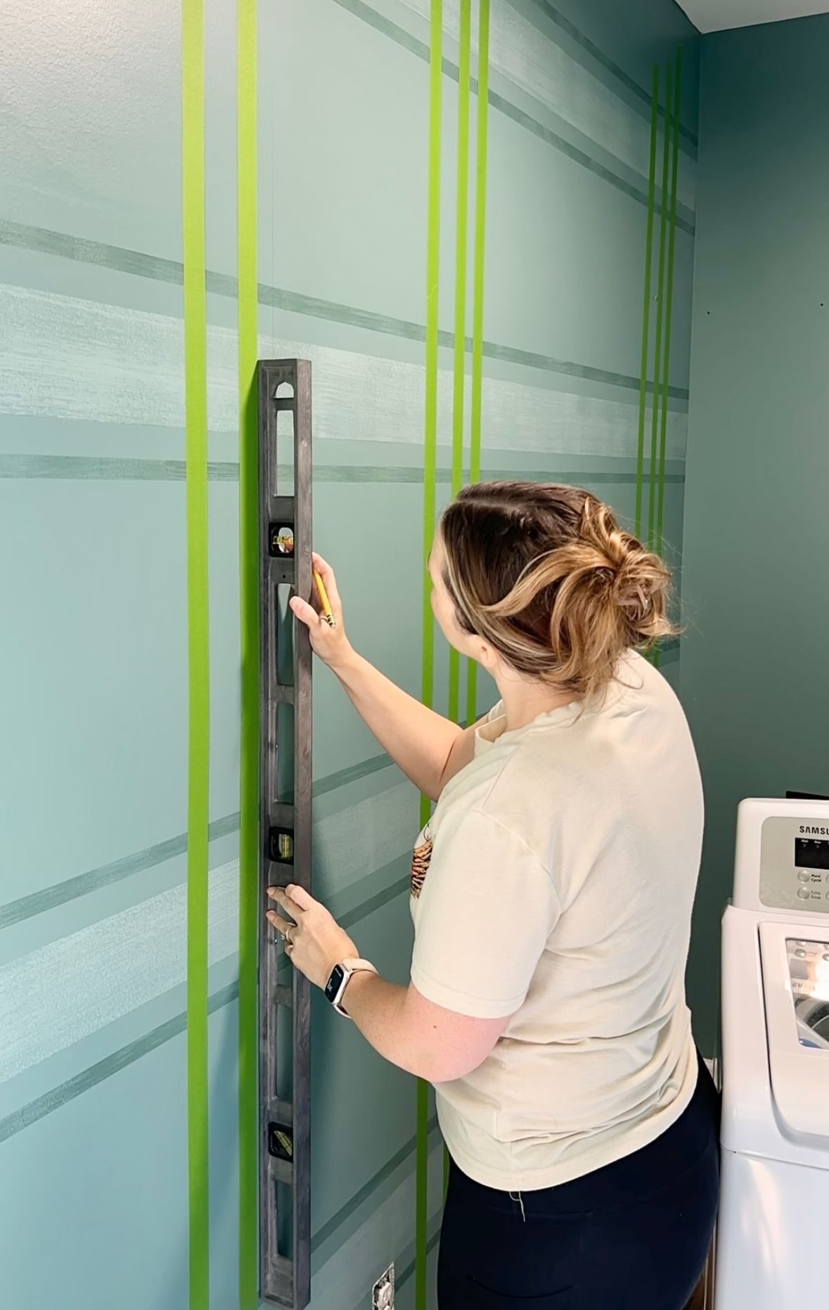 Katie Sharpe Measuring Vertical lines on a wall with a level
