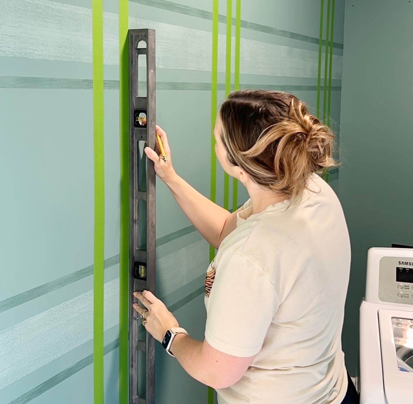 Katie Sharpe Measuring Vertical lines on a wall with a level