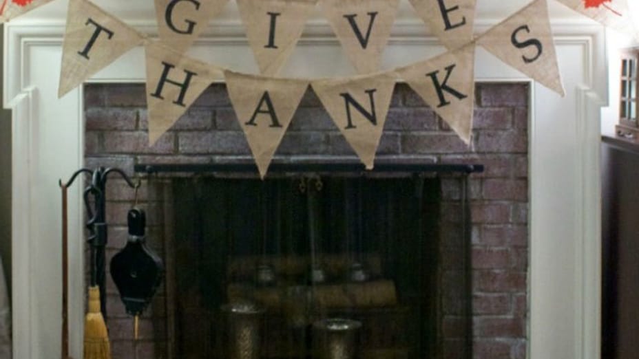 Whitewashed brick fireplace with a banner above that says Give Thanks